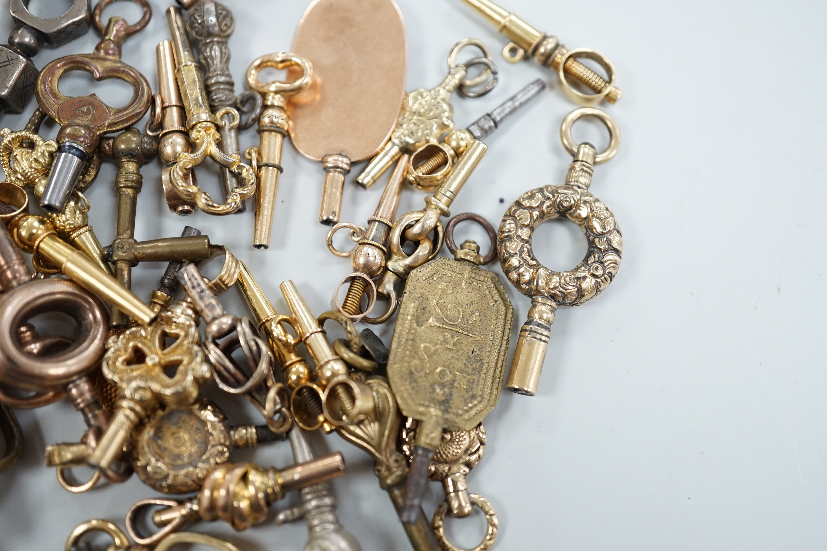 Forty assorted mainly 19th century yellow metal, yellow metal overlaid and base metal small watch keys, including trade insignia and keys for turning in one direction, largest 52mm, together with a limited edition copy,